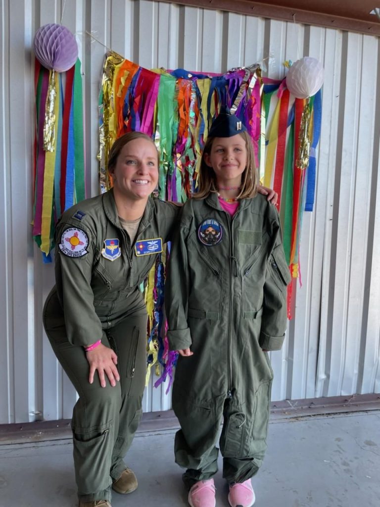 Pilot posing with child in flight suits